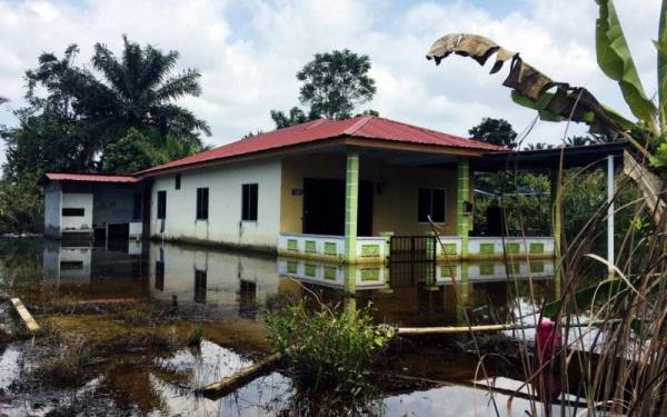 Keadaan halaman rumah beberapa mangsa di Sungai Rambai masih digenangi air 'banjir termenung' sejak seminggu lepas.- Foto Bernama