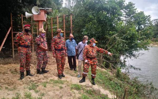 Md Hilman (kanan) meninjau keadaan Sungai Dungun di Kampung Pasir Raja serta memeriksa keberkesanan sistem amaran banjir di lokasi berkenaan pada Rabu.