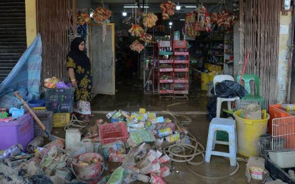 Zaini mengumpul barang barang rosak di hadapan kedainya di Taman Seri Nanding untuk dilupuskan.