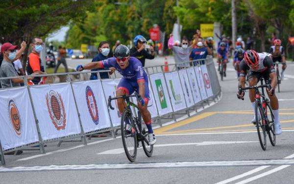 Atlet basikal Team Sapura Cycling Mohammad Saari Amri Abd Rasim (jersi biru) meraikan kemenangannya selepas berjaya menjuarai acara Lepas Beramai-ramai Lelaki Elit pada Kejohanan Berbasikal Lebuhraya Kebangsaan 2021, Bukit Katil, hari ini. - Foto Bernama