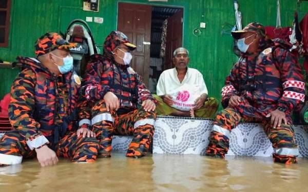 Nazili (kanan) bersama Zainal (dua dari kiri) bertanya khabar penduduk semasa turun padang meninjau situasi terkini banjir di Kampung Legeh, Ayer Lanas, Jeli pada Khamis.