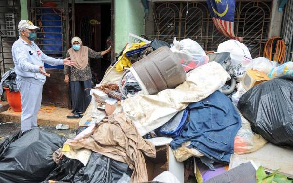 Annuar (kiri) agak terkejut melihat longgokan sampah selepas banjir ketika hadir pada Program Bantu Hingga Selesai (BAHIS) di Taman Sri Muda Seksyen 25 hari ini. -Foto Bernama