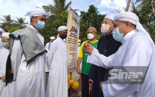 Fadzil (dua, kanan) dan Mudir Kompleks Pendidikan Islam Darul Hidayah, Johari Morad (kanan) berbual dengan pelajar pada Majlis Pecah Tapak Pondok Warga Emas LZNK di Kompleks Pendidikan Islam Darul Hidayah pada Jumaat.