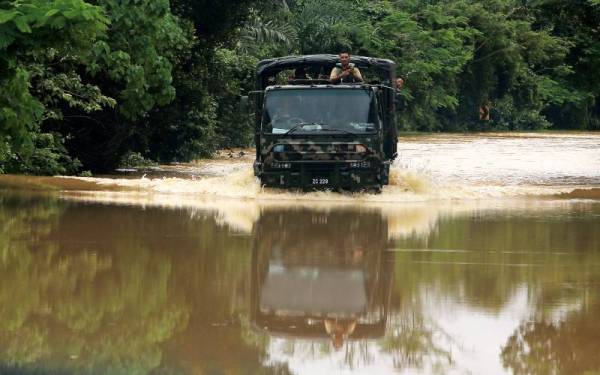 Sebuah lori ATM yang membawa mangsa banjir untuk dihantar ke Pusat Penempatan Sementara (PPS) terdekat dilihat meredah laluan Jalan Tampin-Gemas yang dinaiki air ekoran hujan lebat sejak pukul 5 pagi tadi hari ini. - Foto Bernama