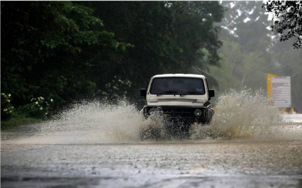 Sebuah kenderaan pacuan empat roda dilihat meredah laluan Jalan Tampin-Gemas yang dinaiki air ekoran hujan lebat sejak pukul 5 pagi semalam, ketika tinjauan pada Ahad. - Foto Bernama 