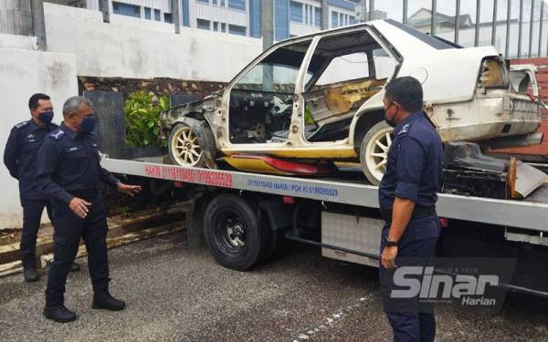 Ramli menunjukkan trak tunda dan kereta dimana sebahagian komponen telah dileraikan yang dirampas susulan penahanan anggota Geng Abu Pandan, di sini baru-baru ini.