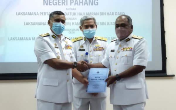 Kamaruszaman (tengah) menyaksikan simbolik penyerahan dokumen serah terima tugas antara Amran (kiri) dan Kamal Ariffin yang dilantik sebagai Pengarah Maritim Negeri Pahang yang baharu dalam satu majlis di sini pada Selasa.