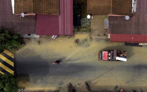 Pemandangan udara menunjukkan penduduk mula pulang ke kediaman masing-masing bagi melakukan kerja-kerja pembersihan selepas banjir surut di Taman Pinggiran Sungai Kelamah pada Selasa. - Foto Bernama