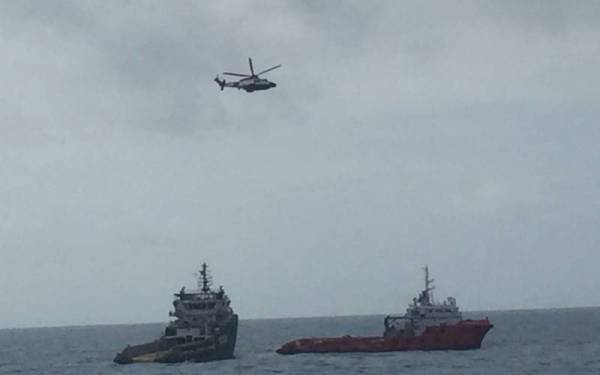 Kapal hantu (kiri) yang hanyut sehingga memasuki perairan negara berjaya ditunda ke lokasi lebih selamat pada Selasa. - Foto ihsan Maritim Malaysia