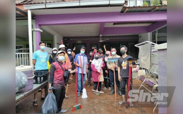 Mustafa (tengah) semasa menyertai aktiviti gotong-royong di Dengkil minggu lalu.