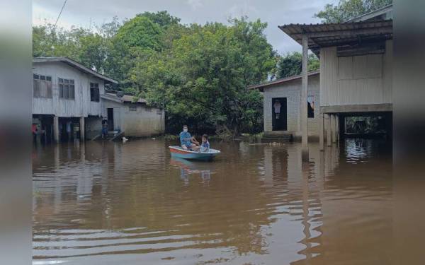 Abdullah bersama cucunya terpaksa menggunakan bot selepas rumah mereka di Kampung Gual Tok Deh dilanda 'banjir termenung'.