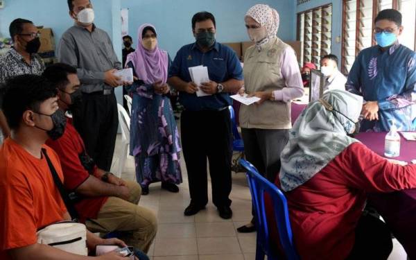 Timbalan Menteri di Jabatan Perdana Menteri (Tugas-Tugas Khas) Datuk Mastura Mohd Yazid (dua, kanan) dan Pengerusi Jawatankuasa Bencana Daerah Klang Mohd Faizal Abdul Raji (tiga, kanan) beramah mesra bersama mangsa banjir ketika hadir membuat tinjauan agihan Bantuan Wang Ihsan (BWI) dan Bantuan Selangor Bangkit (BSB) di Dewan Majlis Pengurusan Kominiti Kampung (MPKK) Kampung Lombong Seksyen 29 Shah Alam hari ini. - Foto Bernama