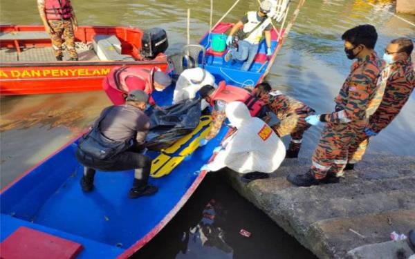 Anggota bomba mengangkat mayat mangsa yang ditemukan terapung di Sungai Tinggi untuk diserahkan kepada pihak polis pada Khamis. - Foto ihsan Bomba Perak