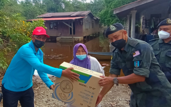 Ku Ardanan (kiri) bersama Azhari (kanan) menyampaikan bantuan kepada penduduk Kampung Tersang, Rantau Panjang yang terkesan dengan banjir pada Jumaat.