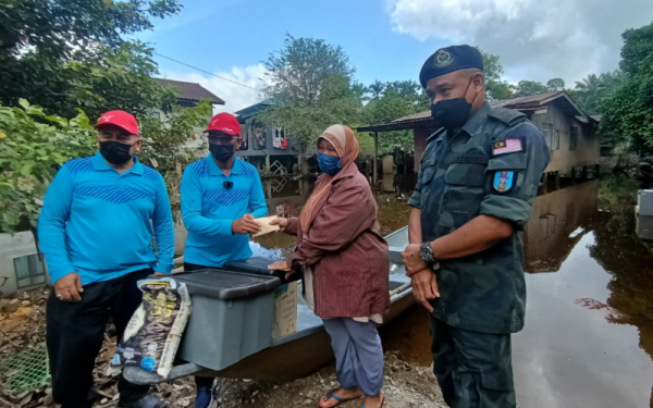 Azhari (kanan) bersama Ku Ku Ardanan (dua dari kiri) turun padang menyampaikan bantuan banjir bersama Syarikat Al Tamim World Sdn Bhd di Kampung Tersang, Rantau Panjang pada Jumaat.