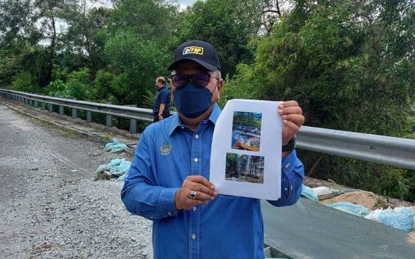 Mohd Zolkafly menunjukkan gambar di lokasi mendapan tanah di Jalan Ampang - Jelapang