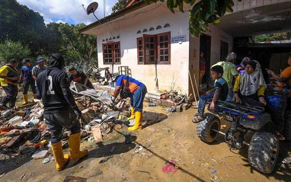 Sukarelawan daripada pelbagai agensi kerajaan dan bukan kerajaan tampil membantu penduduk Kampung Spang Loi yang terjejas akibat banjir. - Foto Bernama