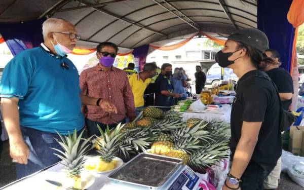 Mahfuz (kiri) ketika meninjau Karnival Jualan Keluarga Malaysia di tapak pekan sehari di Pekan Langgar, Pokok Sena pada Sabtu.