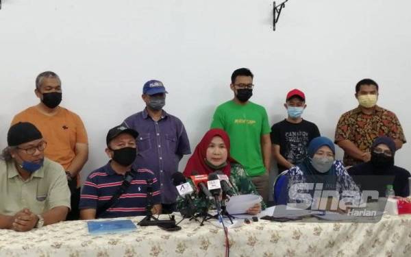 Lele Suzana (tengah, duduk) pada sidang akhbar di Dewan Kampung Paya, Kampong Bharu di sini pada Sabtu.