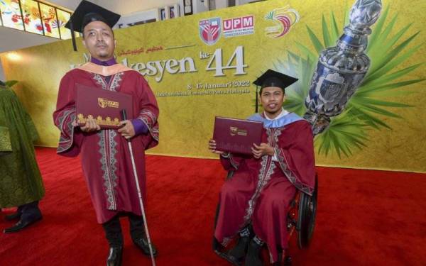 Atlet sepak takraw kebangsaan, Muhammad Kamal Ishak (kanan) bersama graduan Ijazah Sarjana Bahasa Melayu yang buta kedua mata, Khairullah Affarouk Paiman selepas majlis Konvokesyen Universiti Putra Malaysia (UPM) ke-44 pada Sabtu. - Foto Bernama