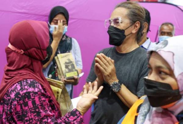 Amy ketika menyantuni mangsa banjir di PPS Institut Kemahiran Belia Negara (IKBN) di Muar. Foto: Gempak/Awani