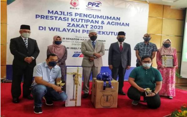 Idris (berdiri, tiga dari kiri) bersama pembayar zakat yang menang cabutan bertuah bagi Kempen Year End Zakat.