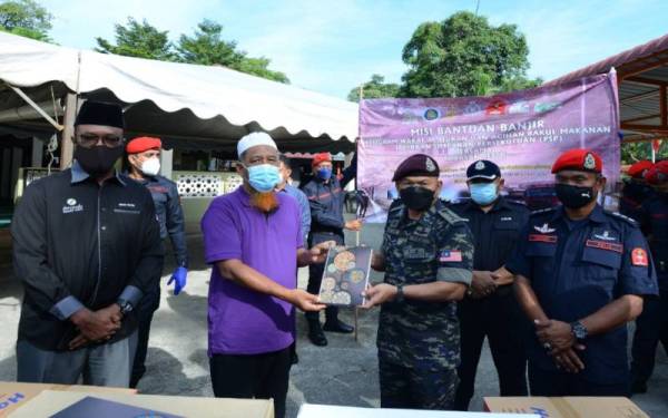 Mastor (dua dari kanan) menyampaikan sumbangan kepada kariah Surau At-Taqwa yang diterima oleh Mustafa ketika program misi bantuan banjir di Surau At-Taqwa Taman Sri Muda pada Rabu.