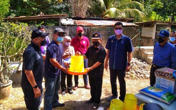 Ahmad (dua dari kanan) menyampaikan bantuan kepada Muhammad Amirul Farie (dua dari kiri) ketika melawat tapak reban ayam kampung di Kampung Baru Bentong pada Khamis.