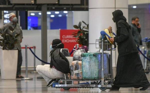 Jemaah yang baru pulang dari mengerjakan umrah tiba di Lapangan Terbang Antarabangsa Kuala Lumpur (KLIA).- Foto Bernama 