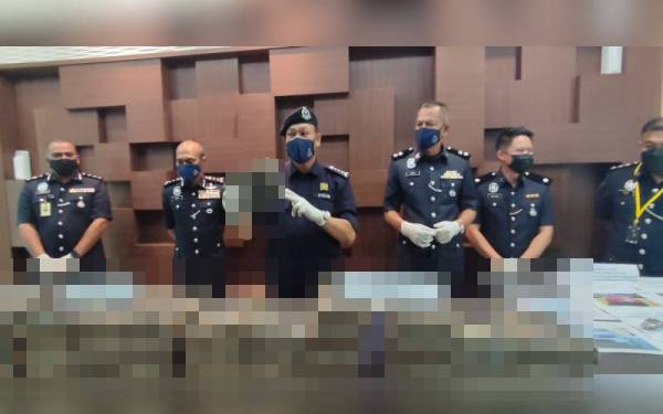 Ketua Polis Kedah, Komisioner Wan Hassan Wan Ahmad (tengah) menunjukkan dadah jenis ganja yang dirampas pada sidang akhbar di Ibu Pejabat Polis Kontijen (IPK) Kedah, di sini, pada Ahad.