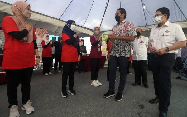 Khairy Jamaluddin (dua, kanan) bersama Setiausaha Kementerian Kesihatan Malaysia. Datuk Seri Mohd Shafiq Abdullah (kanan) beramah mesra dengan kakitangan jabatan kesihatan selepas Majlis Pelancaran Inisiatif Mengakhiri AIDS melalui kerjasama Pintar GO-NGO Model KK 2.0 Peringkat Kebangsaan di Klinik Kesihatan Pandamaran pada Ahad. - Foto Bernama