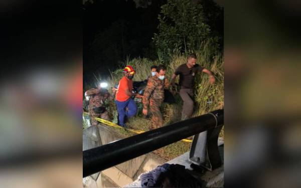 Anggota bomba mengusun mayat remaja yang lemas dalam sungai di Taman Masai Utama, Pasir Gudang, pada malam Ahad.