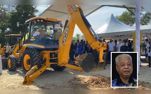 Gambar kecil: Ismail Sabri mengorek tanah menggunakan jentolak sebagai gimik perasmian pecah tanah Ibu Pejabat FAM dekat sini, pada Isnin.