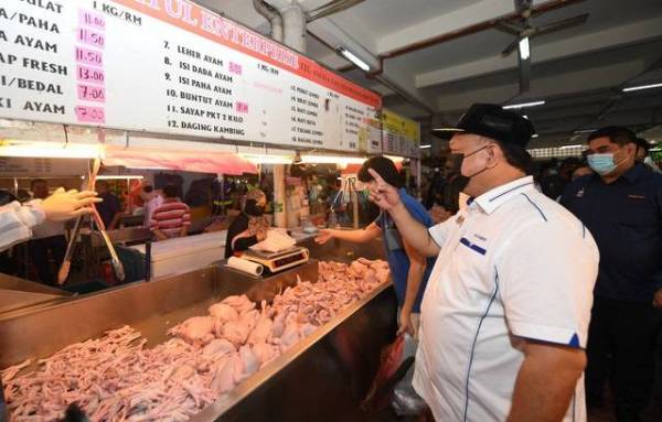 Alexander (dua, kanan) bersama Menteri Pembangunan Masyarakat dan Kesejahteraan Rakyat Sabah Datuk Ir Shahelmay Yahya (kanan) meninjau harga ayam yang dijual di Pasar Besar Kota Kinabalu pada Isnin.
