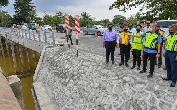 Fadillah berdiri di atas Jambatan Dengkil yang telah dibaik pulih sepenuhnya setelah runtuh akibat hakisan arus deras Sungai Langat semasa banjir di Dengkil. - Foto Bernama 