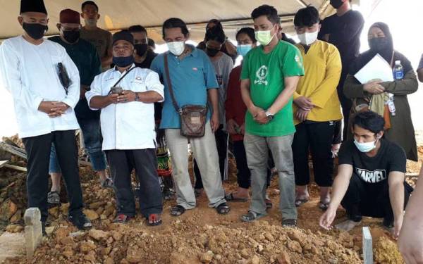 Che Zakaria (kiri), Sabri (tengah) dan ahli keluarga serta rakan arwah hadir pada pengebumian dua mangsa lemas di Tanah Perkuburan Islam Mutmainnah Pasir Gudang, Kampung Cahaya Baru, Padir Gudang, pada Selasa.