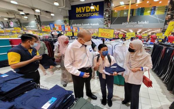 Ameer (dua dari kiri) dan Pengarah Eksekutif Mydin, Datin Dr Siti Hawa Mohd beramah mesra dengan salah seorang murid yang menerima bantuan.