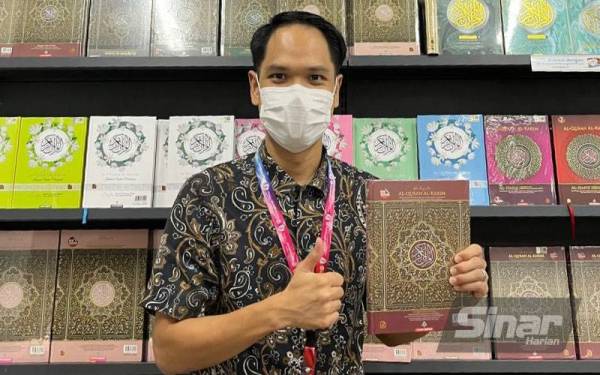 Izzat menunjukkan naskah al-Quran yang akan dijual pada Jualan Gudang Karangkraf 2022.