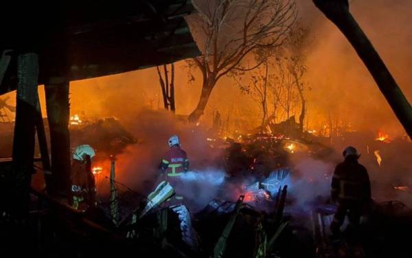 Usaha memadamkan kebakaran rumah setinggan sedang dilakukan oleh pasukan bomba di kawasan belakang sebuah sekolah di Kolombong, Kota Kinabalu. 