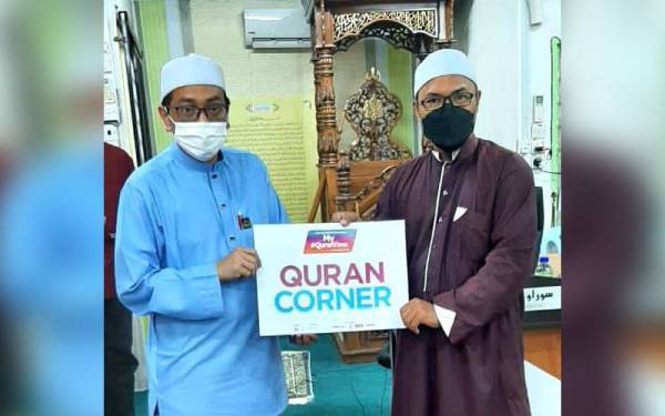 Ketua Unit Pembangunan dan Penyelidikan Yayasan Warisan Ummah Ikhlas, Ustaz Safri Muhammad Zein (kiri) ketika sesi penyerahan al-Quran kepada Pengerusi Surau Nurul Iman, Kampung Lombong, Muhamad Nor Basiron.