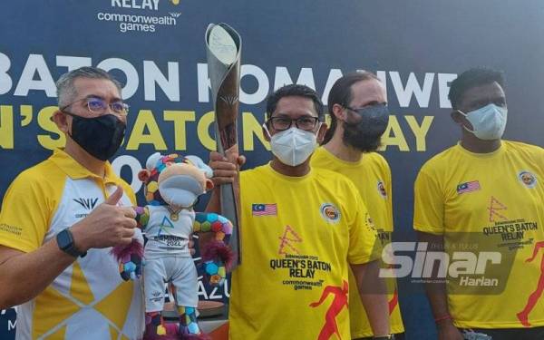 Ahmad Faizal (dua dari kanan) memegang baton pada Larian Baton Komanwel sempena Queen's Baton Relay Commonwealth Games 2022 di Manjoi.