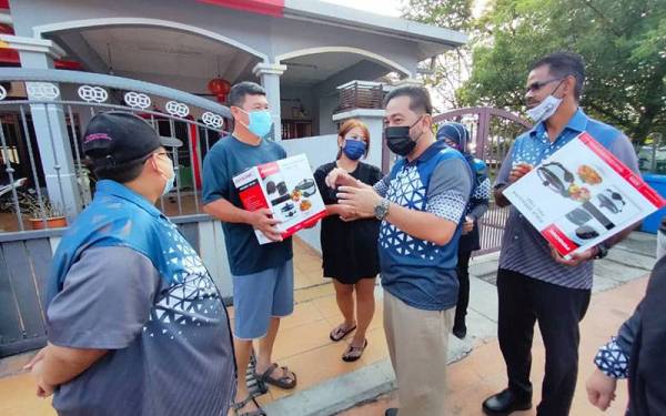 Zamani (dua kanan) menyampaikan sumbangan periuk serba guna kepada mangsa banjir di Taman Sri Muda, Seksyen 25, Shah Alam pada Ahad