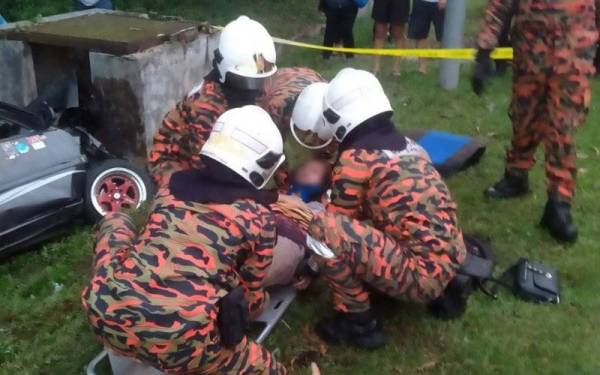 Anggota bomba memberi rawatan awal kepada isteri mangsa sebelum dibawa ke hospital.