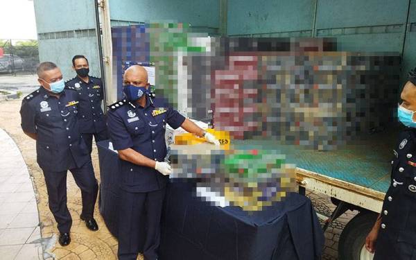 Anbalagan menunjukkan arak seludup yang dirampas pada sidang akhbar di IPD Serdang pada Rabu.