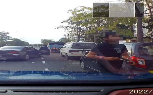 Tangkap layar video pemandu kereta Proton Perdana berlagak samseng yang bertindak memotong barisan berhampiran persimpangan lampu isyarat Jalan Setia Gemilang U13/45B, Ahad lalu.