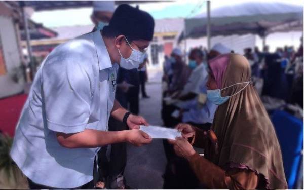 Pengerusi Lembaga Kemajuan Pertanian Muda (MADA), Ahmad Tarmizi Sulaiman (kiri) menyerahkan zakat Pertubuhan Peladang Kebangsaan (Nafas) pada Majlis Penyampaian Geran Bantuan Kerajaan Wilayah II Jitra dan Pelancaran Kedah Barang Bekalan Ladang (BBL) di Pertubuhan Peladang Kawasan (PPK) MADA E-II Kubang Sepat, Ayer Hitam, di sini, pada Khamis.