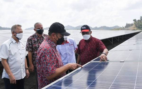 Ahmad Samsuri (tengah) bersama Takiyuddin (kanan) semasa melawat projek solar berskala besar berkapasiti 29.99 MWac di Kampung Tok Arun Mukim Kuala Paka, Dungun hari ini. - Foto Bernama