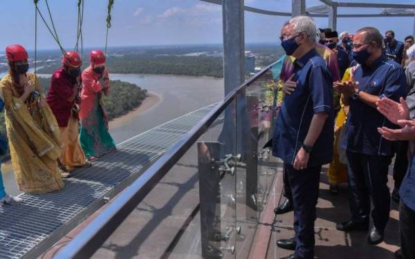 Perdana Menteri Datuk Seri Ismail Sabri Yaakob tertarik melihat peserta “skywalk” yang memakai pakaian tradisional semasa melakukan aktiviti tersebut ketika mengadakan lawatan ke Menara Kuantan 188 di sini hari ini. - Foto Bernama 