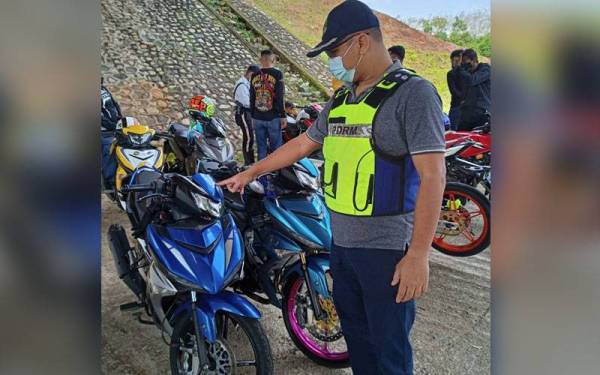 Zainon Abidin menunjukkan motosikal yang menggunakan nombor plat tidak mengikut peraturan.