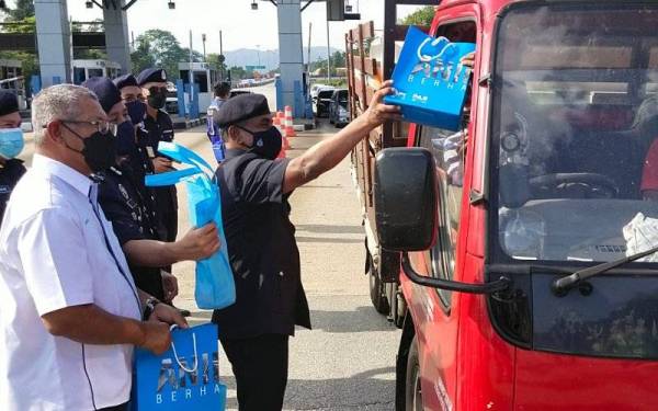 Ramli mengedarkan ' goodies bag' kepada pengguna jalan raya sempena Majlis Pelancaran Ops Selamat 17 Tahun Baharu Cina Kontinjen Pahang di Plaza Tol Gambang di sini pada Jumaat.